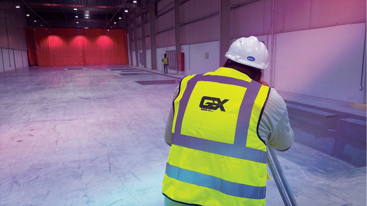 GeoX surveyor taking measurements inside an industrial building.